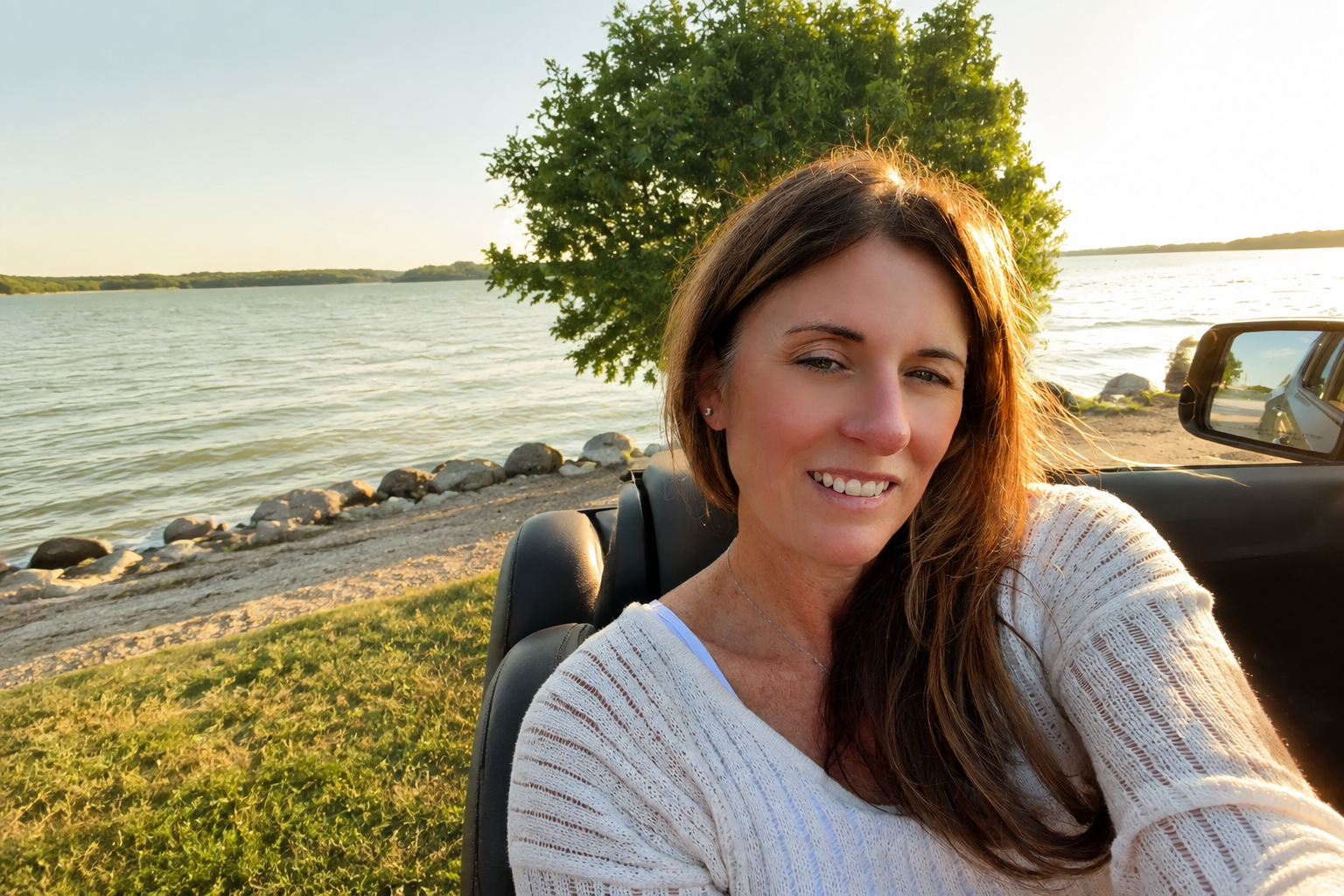 Sheila Greene sitting beside the lake in warm evening light