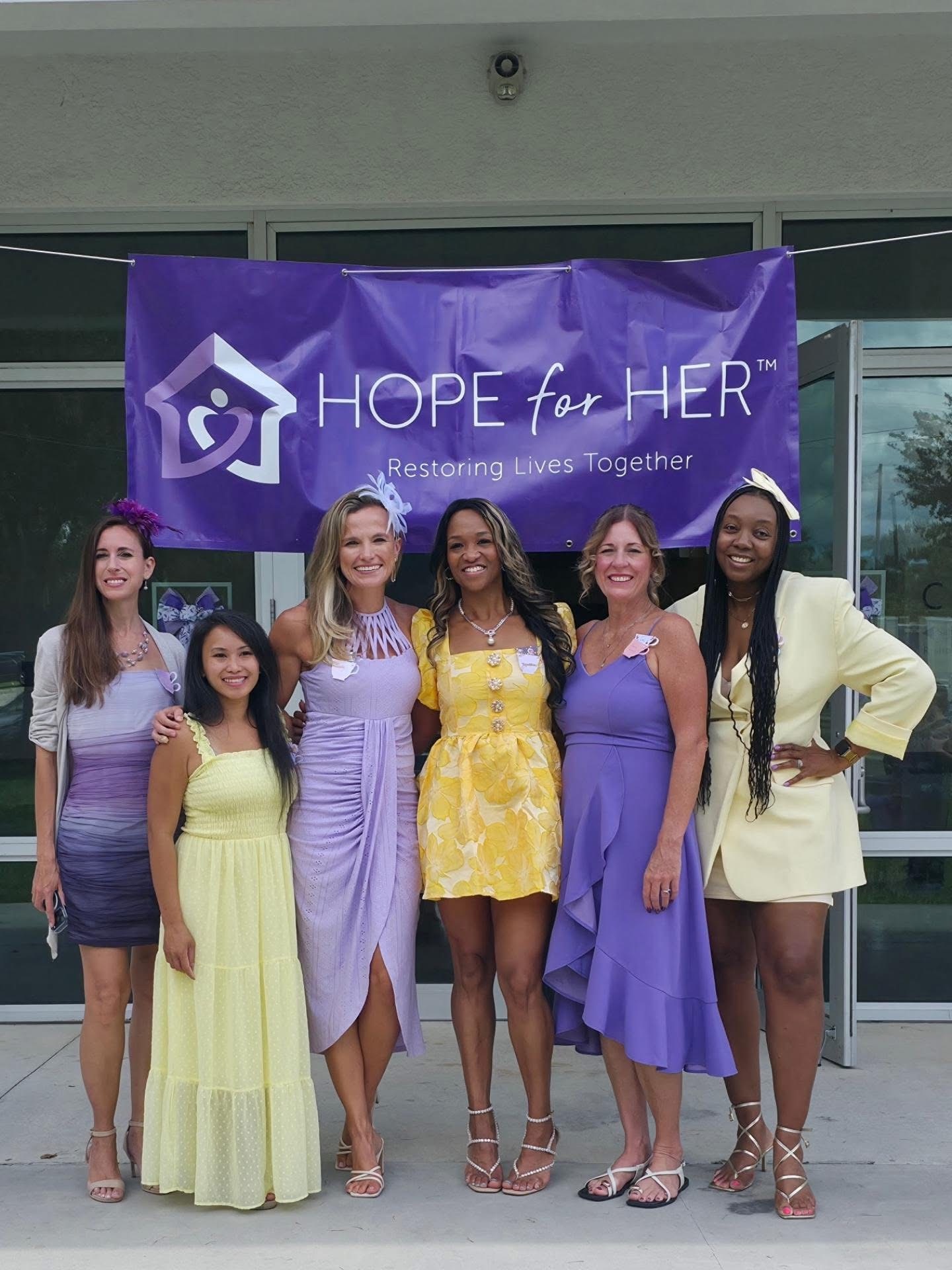 Hope for Her event attendees with Takara Fuller-Doby beneath the Hope for Her banner